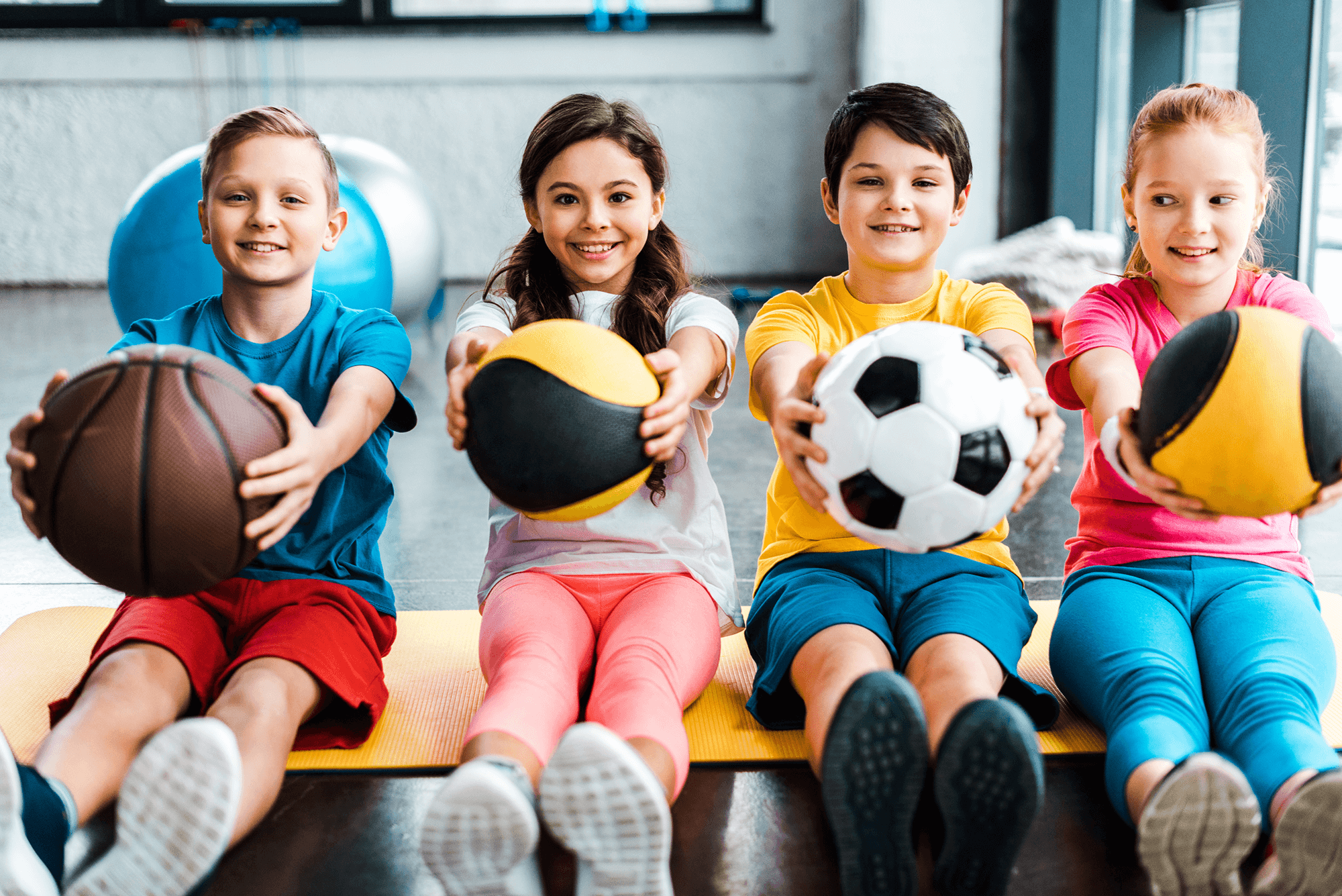 cheerful-kids-sitting-on-fitness-mat-with-balls-2024-11-19-08-04-28-utc 1